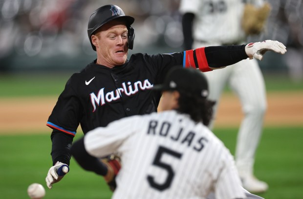White Sox third baseman Josh Rojas receives a late throw from the outfield as Marlins first baseman Eric Wagaman slides in safely for a two-run triple in the eighth inning on May 10, 2025, at Rate Field. (Chris Sweda/Chicago Tribune)