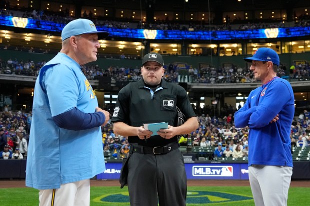 Brewers manager Pat Murphy, left, and Cubs manager Craig Counsell exchange lineups with umpire Jansen Visconti before a game on May 2, 2025, in Milwaukee. (Kayla Wolf/AP)
