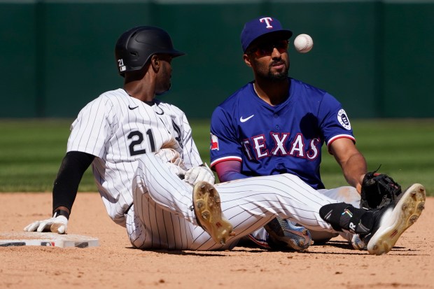Chicago White Sox's Michael A. Taylor, left, is safe at second base with a double as Texas Rangers second baseman Marcus Semien, right, makes a late tag during the ninth inning of a baseball game Sunday, May 25, 2025, in Chicago. (AP Photo/David Banks)