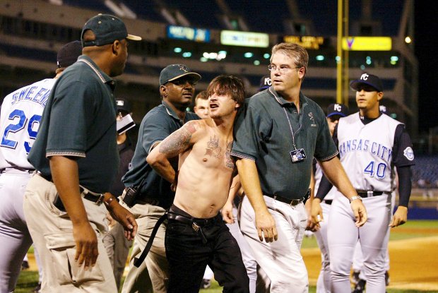 Security officials remove one of two men who jumped from the stands and attacked Royals first-base coach Tom Gamboa during the ninth inning of a game against the White Sox on Sept. 19, 2002, at Comiskey Park. (Ted S. Warren/AP)