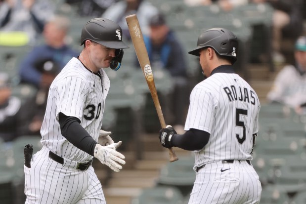 White Sox first baseman Tim Elko high-fives Josh Rojas after hitting a solo home run against the Mariners during the third inning on May 21, 2025, at Rate Field. (Michael Reaves/Getty Images)