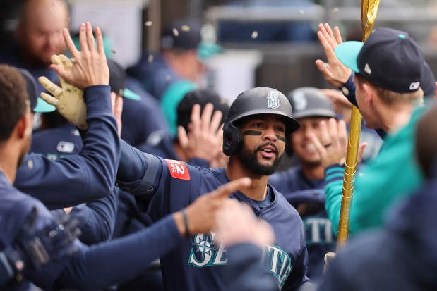 Mariners right fielder Leody Taveras high-fives teammates after hitting a two-run home run against the White Sox during the eighth inning on May 21, 2025, at Rate Field. (Michael Reaves/Getty Images)