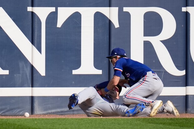 Rangers center fielder Sam Haggerty, right, and left fielder Wyatt Langford collide trying to catch a fly ball from White Sox pinch hitter Austin Slater during the sixth inning on May 24, 2025, at Rate Field. Slater was credited with a triple on the play and later scored in the six-run inning. (Erin Hooley/AP)