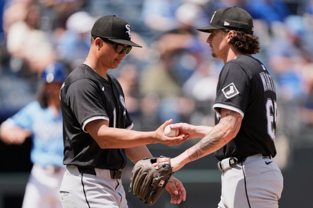 White Sox starter Davis Martin, right, hands the ball to manager Will Venable during a pitching change in the fifth inning against the Royals on May 8, 2025, in Kansas City, Mo. (Charlie Riedel/AP)