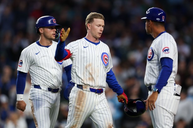 Chicago Cubs outfielder Pete Crow-Armstrong (4) celebrates with Chicago Cubs third base coach Quintin Berry (0) after hitting a sacrifice fly brining in Chicago Cubs second base Nico Hoerner (2) during the fifth inning against the Miami Marlins at Wrigley Field Tuesday May 13, 2025, in Chicago. (Armando L. Sanchez/Chicago Tribune)