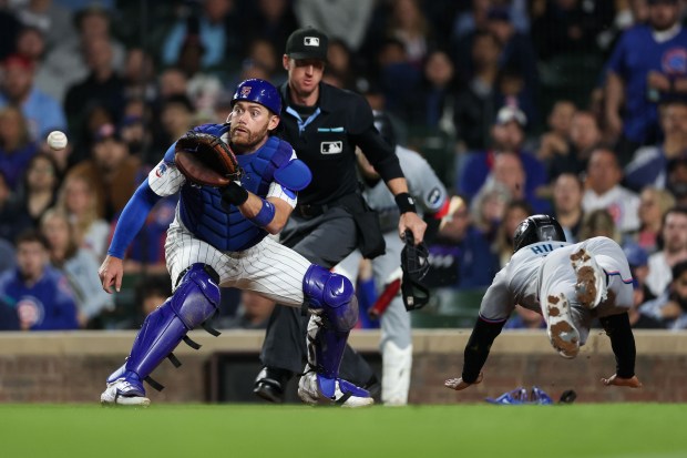 Miami Marlins outfielder Derek Hill (3) scores past Chicago Cubs catcher Carson Kelly (15) during the seventh inning at Wrigley Field Tuesday May 13, 2025, in Chicago. (Armando L. Sanchez/Chicago Tribune)