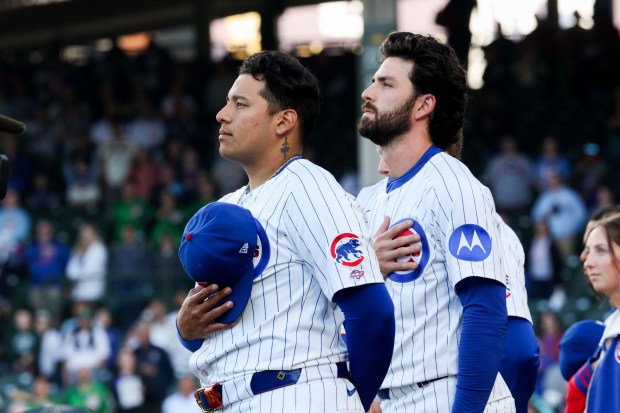 Chicago Cubs catcher Moisés Ballesteros (25) and Chicago Cubs shortstop Dansby Swanson (7) stand during the national anthem before the Cubs play the Miami Marlins at Wrigley Field Tuesday May 13, 2025, in Chicago. (Armando L. Sanchez/Chicago Tribune)