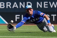 Texas Rangers outfielder Alejandro Osuna  makes a diving attempt on a line drive off the bat...