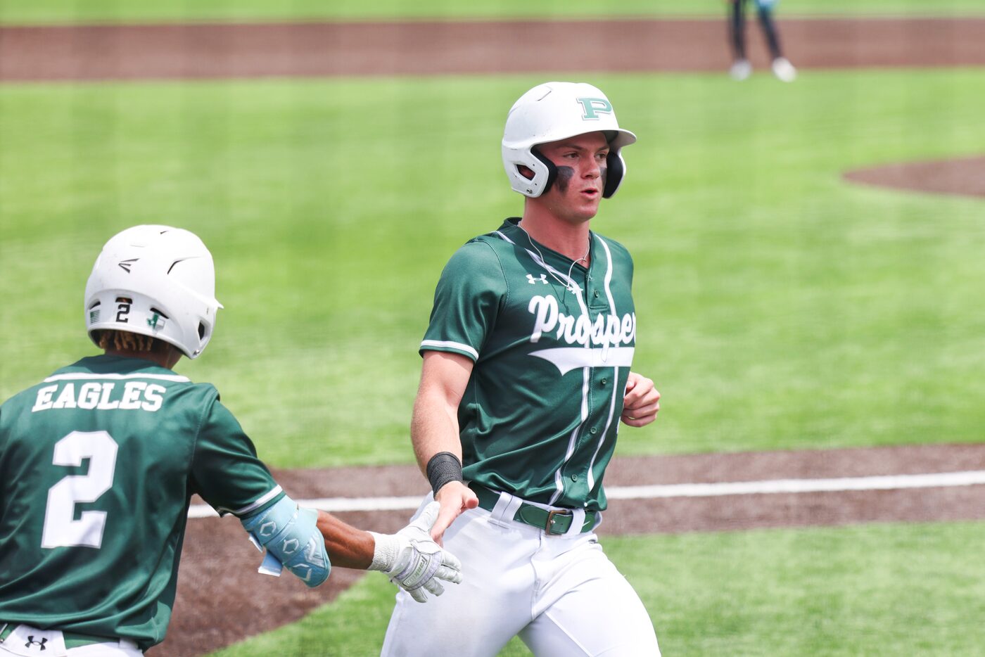 Prosper’s Trevor Ellis high-fives after completing a run during the fifth inning of a...