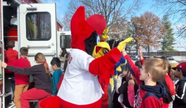 Fredbird greets students at Bierbaum Elementary Tuesday before they enter the new Cardinals-themed bookmobile in partnership with the St. Louis County Library and Cardinals Care. (Spectrum News/Elizabeth Barmeier)