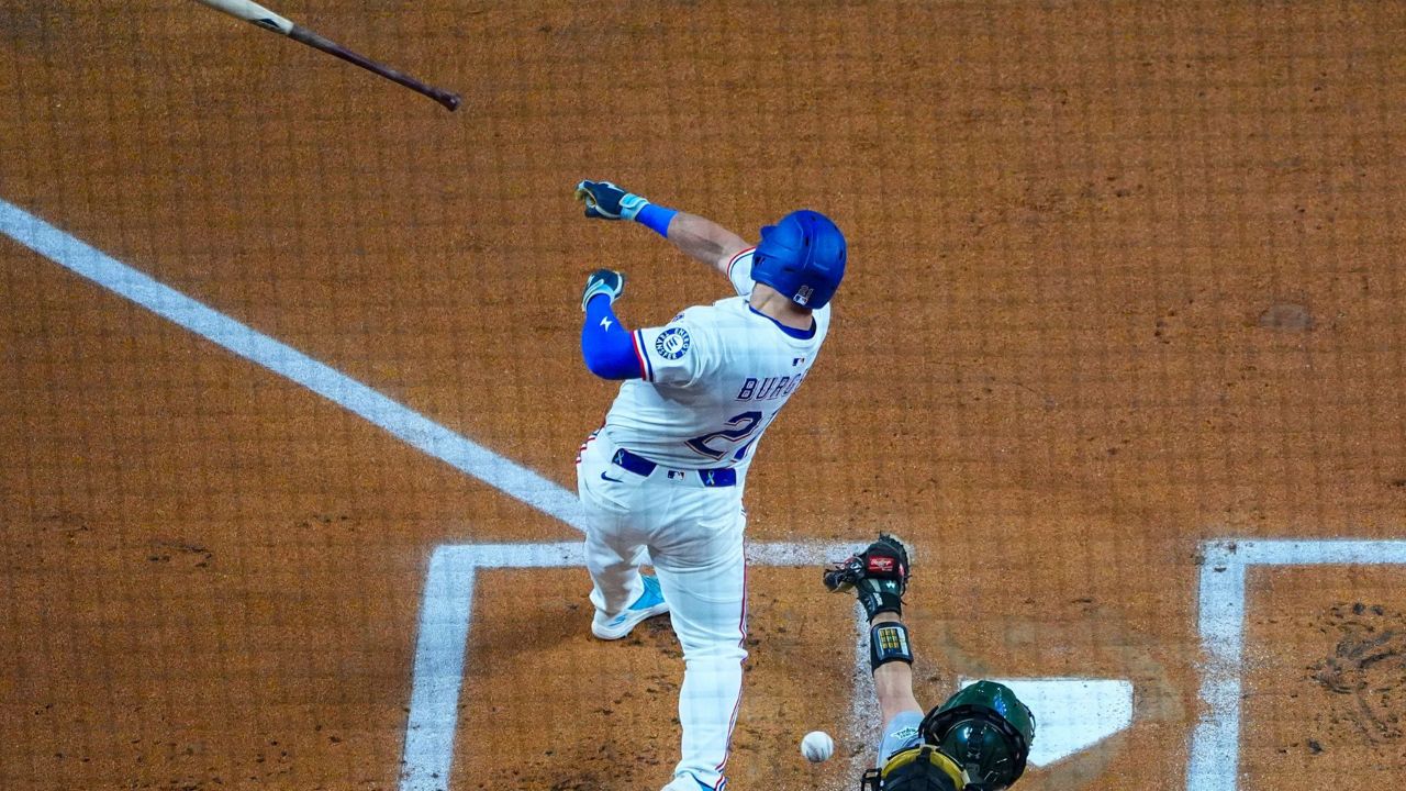 Texas Rangers' Jake Burger loses his bat while swinging at a pitch from Oakland Athletics starting pitcher Luis Severino during the first inning of a baseball game Wednesday, April 30, 2025, in Arlington, TX. (AP Photo/Julio Cortez)