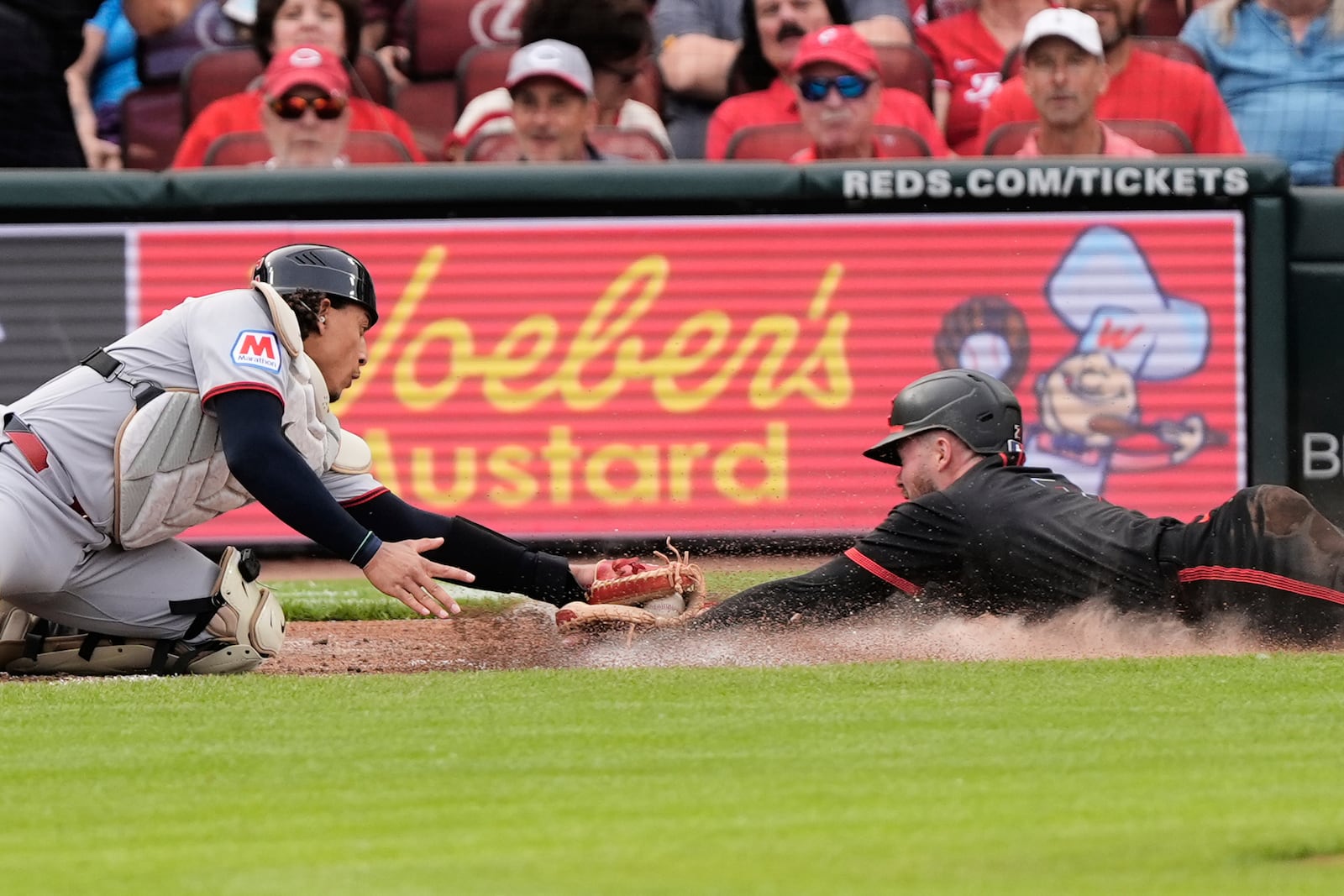 Cincinnati Reds' Gavin Lux, right, is out at home plate as Cleveland Guardians catcher Bo Naylor, left, places a tag during the third inning of a baseball game, Friday, May 16, 2025, in Cincinnati. (AP Photo/Carolyn Kaster)