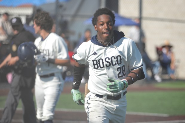 St. John Bosco junior center fielder Miles Clark heads to...