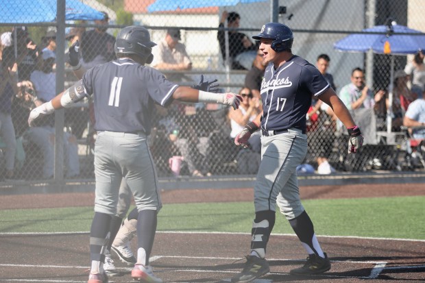 Vista Murrieta designated hitter Vaughn Neckar steps on home plate...