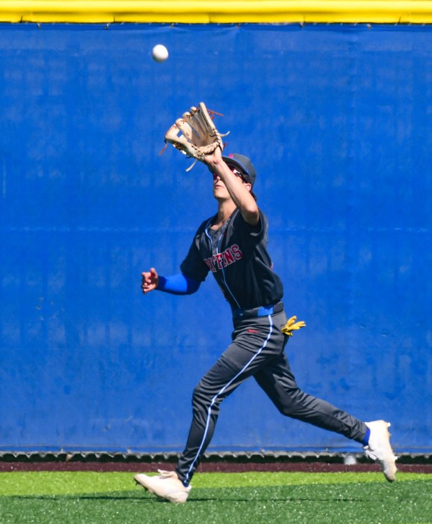 Los Alamitos center fielder Kaden Carrion (13) catches a fly...