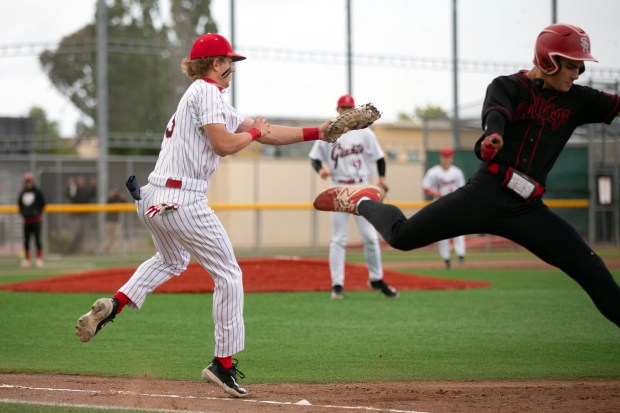 Redwood first baseman Chase Johnson (13) tags out San Rafael’s...