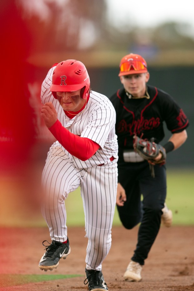 Redwood designated hitter Miles Harrison (8) tries to return to...