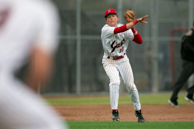 Redwood third baseman Kaelin Christman (16) follows through on his...