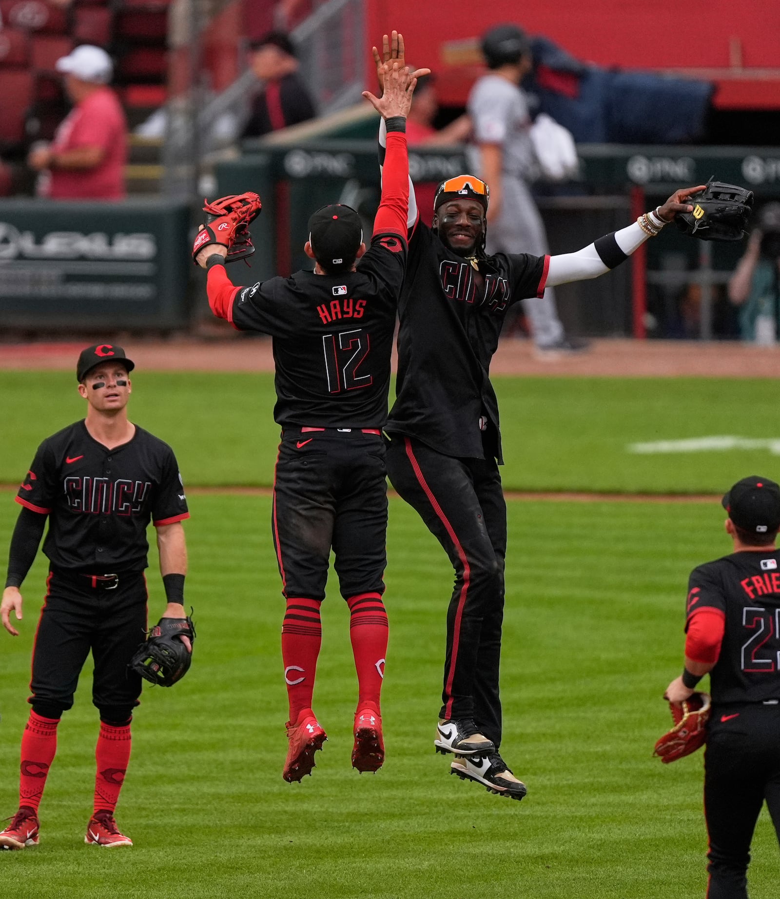 Cincinnati Reds shortstop Elly De La Cruz, center right, and Austin Hays (12) celebrate after winning a baseball game against the Cleveland Guardians, Friday, May 16, 2025, in Cincinnati. (AP Photo/Carolyn Kaster)