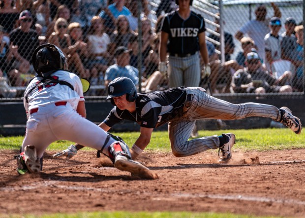 Pleasant Valley's Scotty McKeown (right) dives head first into home...