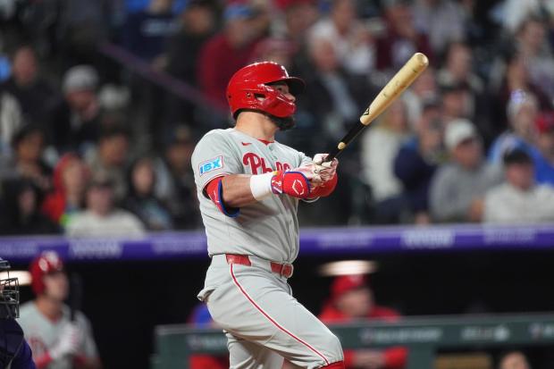 Philadelphia Phillies' Kyle Schwarber follows the flight of his solo home run off Colorado Rockies relief pitcher Ryan Rolison in the seventh inning of a baseball game, Tuesday, May 20, 2025, in Denver. (AP Photo/David Zalubowski)