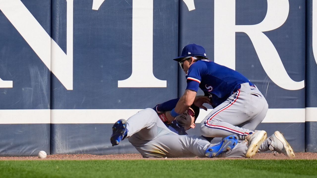 Texas Rangers center fielder Sam Haggerty (0), right, and left fielder Wyatt Langford (36) collide trying to catch a fly ball from Chicago White Sox pinch hitter Austin Slater (15) during the sixth inning of a baseball game Saturday, May 24, 2025, in Chicago. (AP Photo/Erin Hooley)
