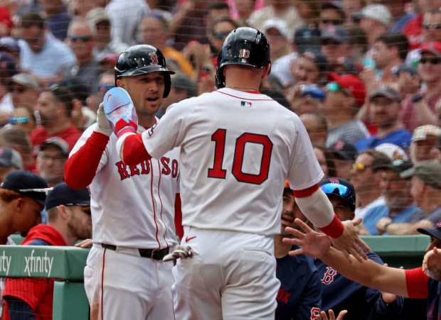Boston Red Sox shortstop Trevor Story (10) is congratulated on scoring on a wild pitch in the second inning during a 5-0 win over the Texas Rangers at Fenway Park. (Staff Photo By Stuart Cahill/Boston Herald)