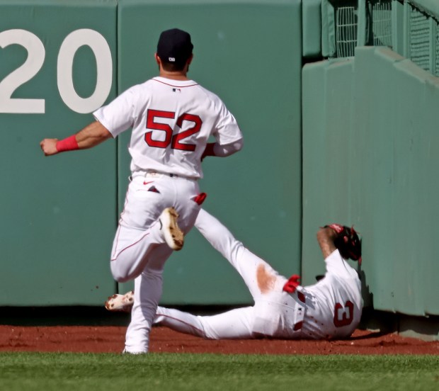 Boston Red Sox outfielder Ceddanne Rafaela (3) crashes into the wall after catching a drive by Texas Rangers third base Josh Jung in the ninth inning during Boston's 5-0 win. (Staff Photo By Stuart Cahill/Boston Herald)