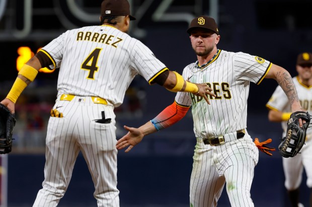 San Diego Padres' Jackson Merrill celebrates with Luis Arraez after making a diving catch on a hit by Los Angeles Angels' Nolan Schanuel in the seventh inning at Petco Park on Monday, May 12, 2025. (K.C. Alfred / The San Diego Union-Tribune)