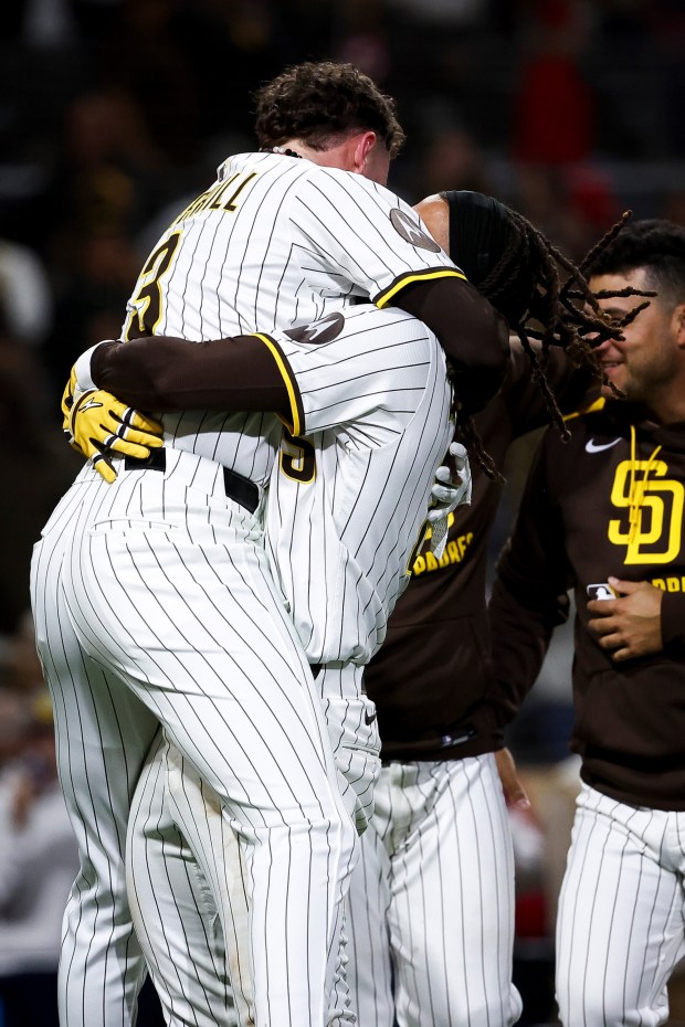 San Diego Padres center fielder Jackson Merrill and right fielder Fernando Tatis Jr. hug after Tatis' game-winning home run against the Los Angeles Angels during the ninth inning at Petco Park on Tuesday, May 13, 2025 in San Diego, CA. (Meg McLaughlin / The San Diego Union-Tribune)