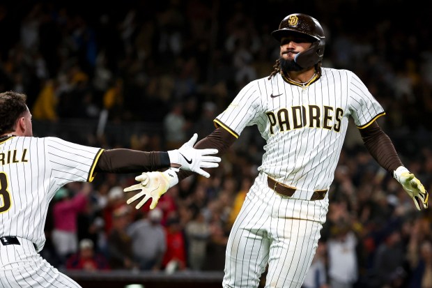 San Diego Padres center fielder Jackson Merrill high fives right fielder Fernando Tatis Jr. after Tatis' game-winning home run against the Los Angeles Angels during the ninth inning at Petco Park on Tuesday, May 13, 2025 in San Diego, CA. (Meg McLaughlin / The San Diego Union-Tribune)