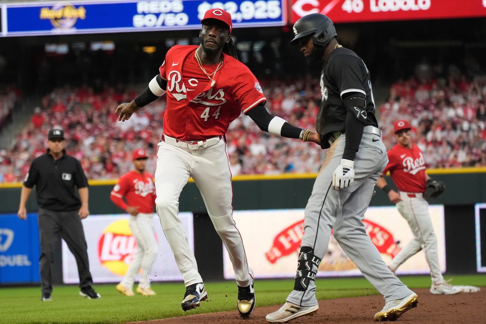 Cincinnati Reds shortstop Elly De La Cruz, left, tags Chicago White Sox's Luis Robert Jr. out during the fifth inning of a baseball game, Wednesday, May 14, 2025, in Cincinnati. (AP Photo/Carolyn Kaster)