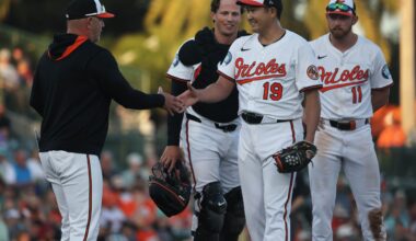Baltimore Orioles starting pitcher Tomoyuki Sugano (19) smiles as he is taken out of the game by manager Brandon Hyde (18) during the fourth inning against the Minnesota Twins at Ed Smith Stadium.