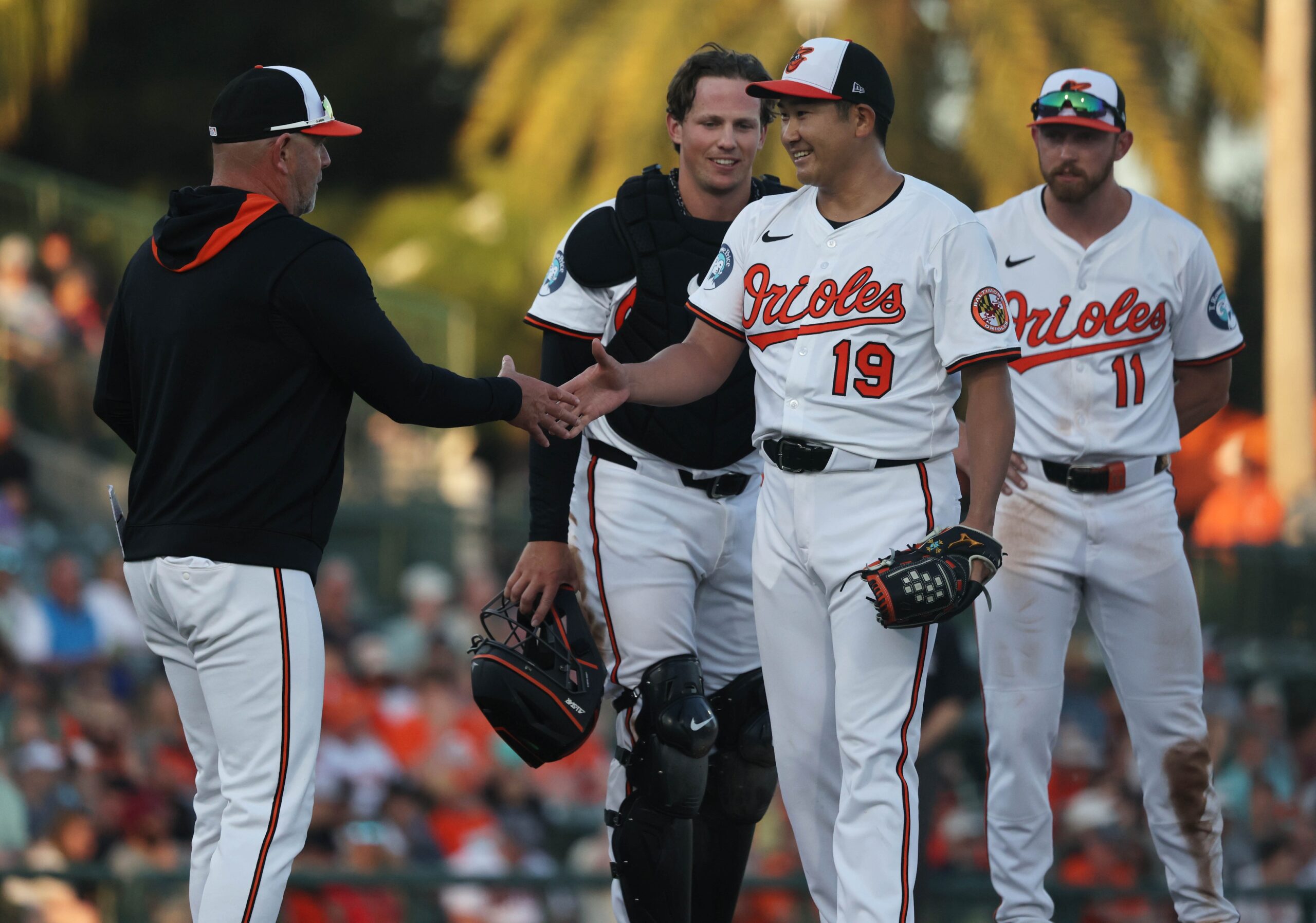 Baltimore Orioles starting pitcher Tomoyuki Sugano (19) smiles as he is taken out of the game by manager Brandon Hyde (18) during the fourth inning against the Minnesota Twins at Ed Smith Stadium.