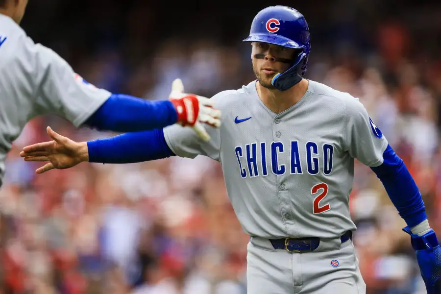 Chicago Cubs second baseman Nico Hoerner (2) high fives a teammate after scoring on a single