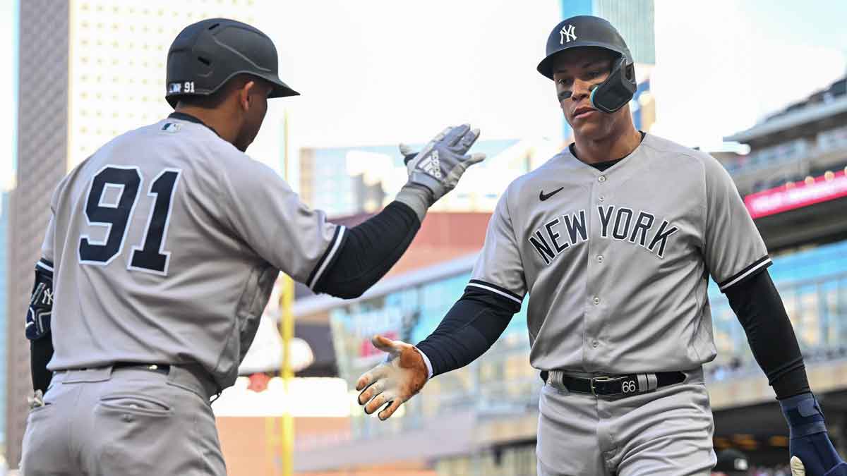 New York Yankees center fielder Aaron Judge (99) celebrates with second baseman Oswald Peraza (91) after scoring a run on a single by third baseman DJ LeMahieu during the first inning at Target Field.