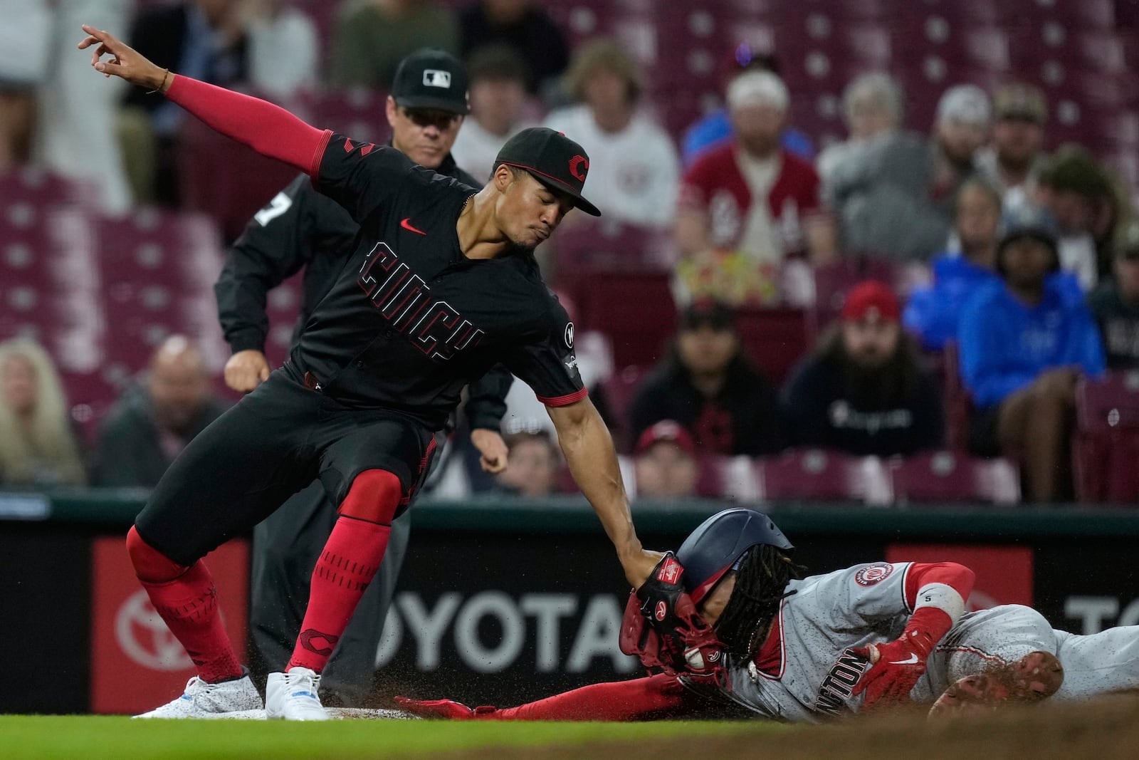 Washington Nationals' CJ Abrams, right, is tagged out as he is caught stealing by Cincinnati Reds third baseman Noelvi Marte, left, during the eighth inning of a baseball game, Friday, May 2, 2025, in Cincinnati. (AP Photo/Carolyn Kaster)
