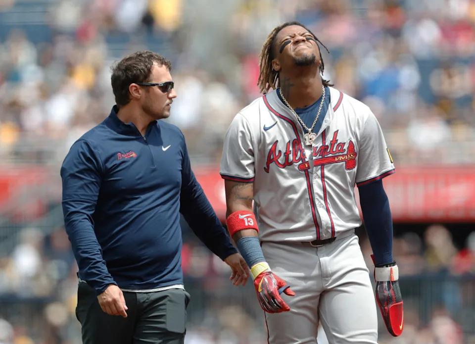 Atlanta Braves right fielder Ronald Acuña Jr. (13) reacts as he leaves the field assisted by a Braves trainer after Acuña suffered an apparent injury on a steal attempt against the Pittsburgh Pirates during the first inning at PNC Park.Charles LeClaire-Imagn Images