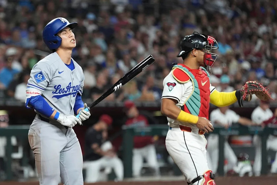Hyeseong Kim, left, reacts to striking out as Arizona Diamondbacks catcher Gabriel Moreno pauses at home plate.