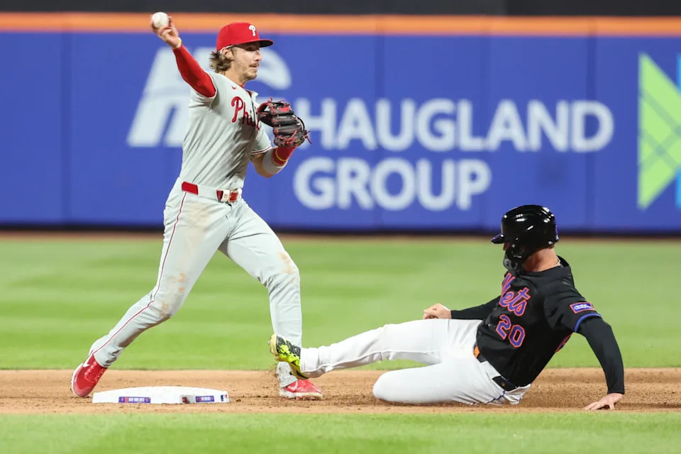 Philadelphia Phillies second baseman Bryson Stott (5) throws past New York Mets first baseman Pete Alonso (20) in the third inning at Citi Field.Wendell Cruz-Imagn Images