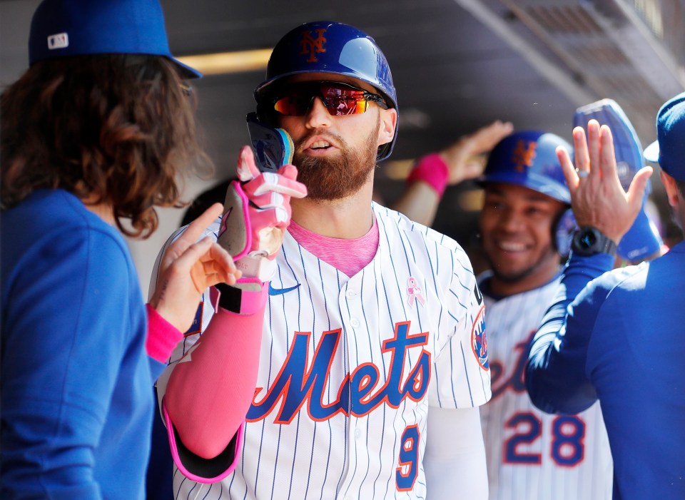Brandon Nimmo #9 of the New York Mets high-fiving teammates.