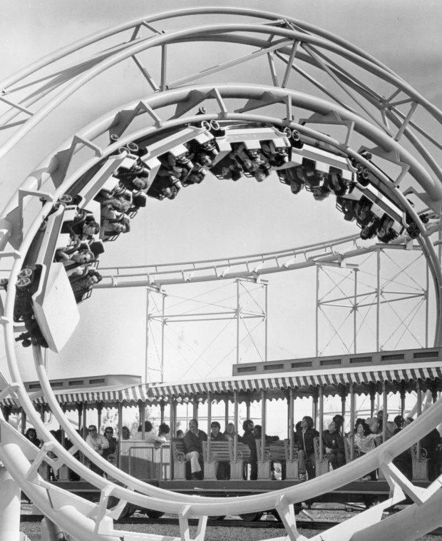 The Turn of the Century ride loops over a train ride, the Great America Scenic Railway, at Marriott's Great America in Gurnee when it opened in 1976. The first loop of the Turn of the Century extended completely over the train during the first of two 360-degree spirals. The ride was re-themed as the Demon in 1980. (Marriott's Great America) 