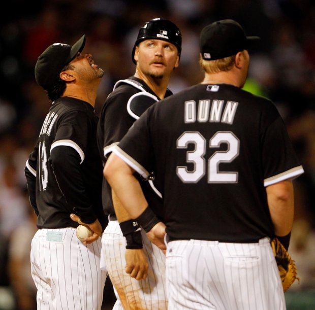 Chicago White Sox manager Ozzie Guillen (13) and catcher A.J. Pierzynski (12) look skyward as rain begins to fall in the seventh inning as the White Sox played the New York Yankees at U.S. Cellular Field on Aug. 2, 2011. (Brian Cassella/Chicago Tribune)