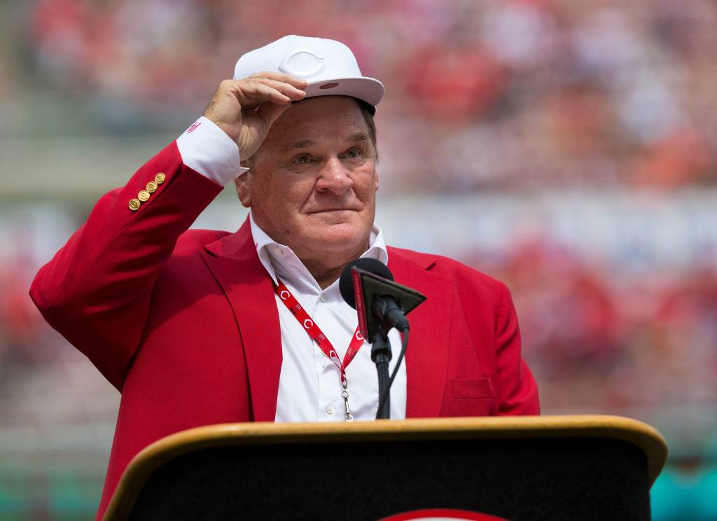 An emotional Cincinnati Reds hall of famer Pete Rose adjusts his cap as he takes the microphone during a pregame ceremony for the unveiling of Pete Rose's bronze statue being installed outside the stadium.