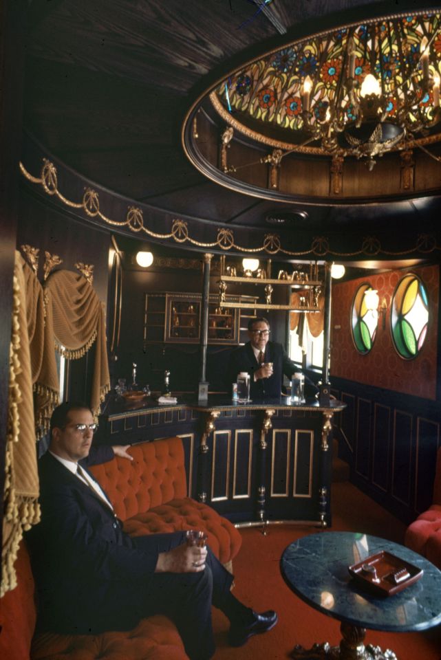 Interior of Roy Hofheinz's private railroad car bar, showing two men in suits.