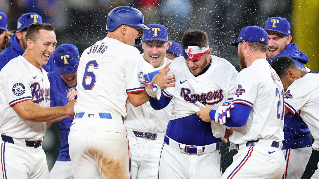 ARLINGTON, TEXAS - MARCH 28: Jonah Heim #28 of the Texas Rangers is congratulated by teammates following a walk-off single in the 11th inning to defeat the Chicago Cubs in the Opening Day game at Globe Life Field on March 28, 2024 in Arlington, Texas.