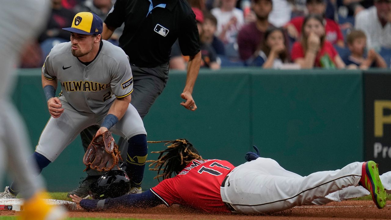 Cleveland Guardians' Jose Ramirez, right, steals third base as Milwaukee Brewers third baseman Caleb Durbin, left, waits for the throw in the fourth inning of a baseball game in Cleveland, Monday, May 12, 2025. (AP Photo/Sue Ogrocki)