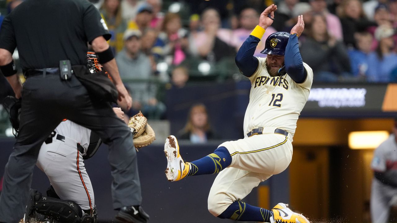 Milwaukee Brewers' Rhys Hoskins (12) slides into home to score during the second inning of a baseball game against the Baltimore Orioles, Monday, May 19, 2025, in Milwaukee.