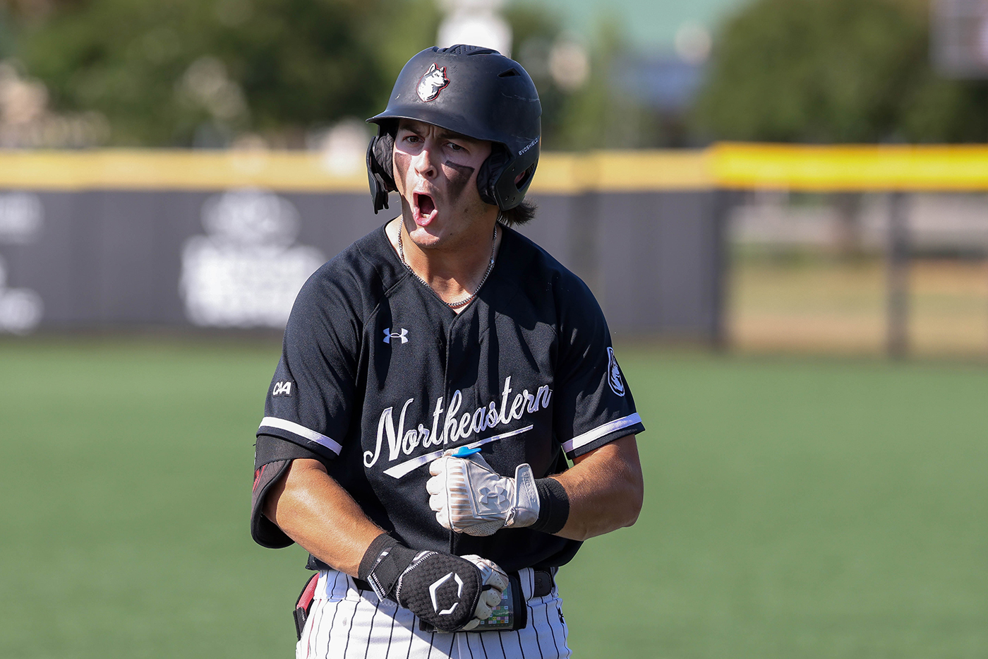 A Northeastern mens baseball player cheers in celebration.