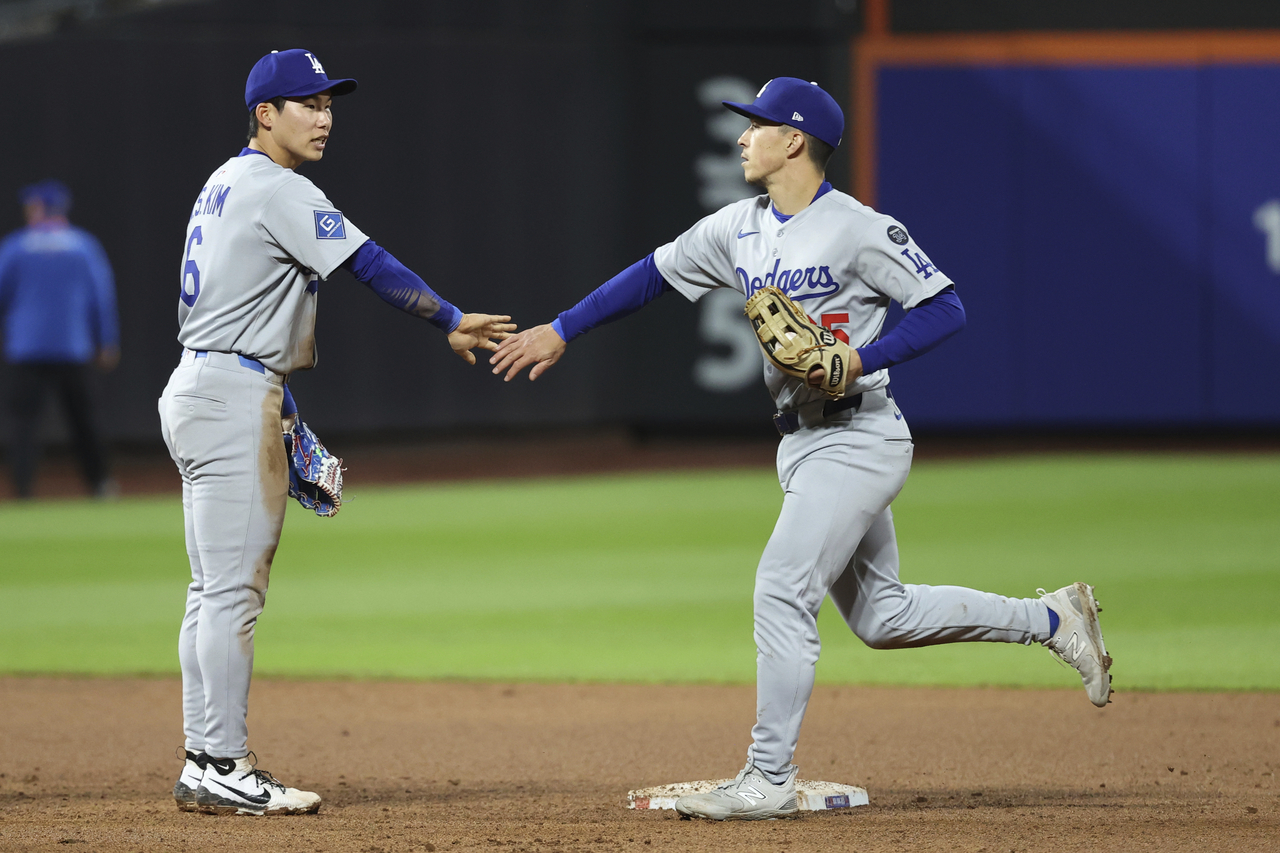 Los Angeles Dodgers' Hyeseong Kim, left, and Tommy Edman, right, react after defeating the New York Mets during a baseball game Saturday in New York. (AP-Yonhap))